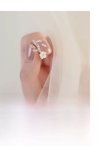 Detail of S925 silver flower ring with marquise zircon leaves on a female finger