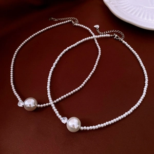 Close-up of elegant pearl necklaces with zircon accents on a luxury red velvet backdrop