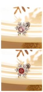 Makro-Detail von Schneeflocken-Ohrringen mit Zirkonia in Rosa und Rot auf einem Tablett