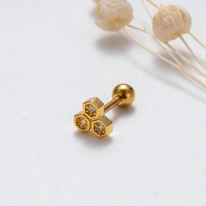 Detailed view of gold honeycomb stud earrings with inlaid crystals on a white background