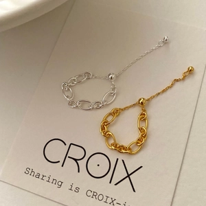 Detail view of minimalist gold and silver chain rings with adjustable sizing