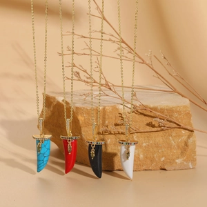 Détail de pendentifs en corne avec zircon en bleu, rouge, noir et blanc, plaqué or