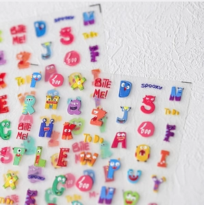 Makroaufnahme von Cartoon-Monster-Alphabet-Nagelaufklebern mit lebhaften bunten Buchstaben