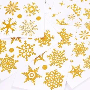 Detail of gold glitter snowflake stickers on white sheets for Christmas window decoration