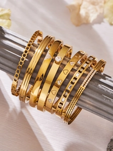 Détail de bracelets en acier plaqué or 18k avec zircons géométriques et motifs en nid d'abeille
