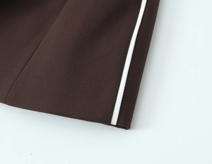 Detailed macro view of dark brown woven fabric with white vertical side stripe trim