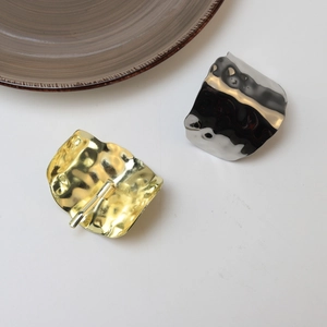 Detail view of gold and silver hammered metal hair clips with textured lava surface