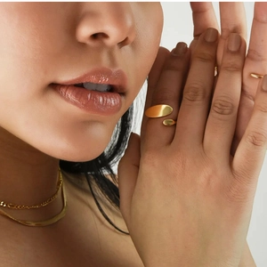 Detail of 18k gold-plated irregular ring and layered necklaces on model neck and hand