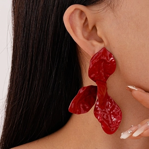 Detail showing red textured flower petal earrings with a glossy spray paint finish