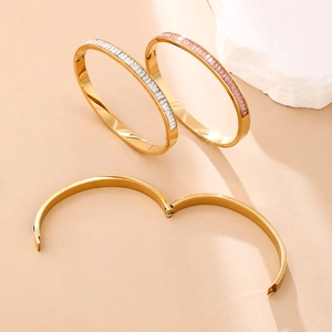 Detail of gold-plated hinged bracelets featuring baguette-cut white and pink stones