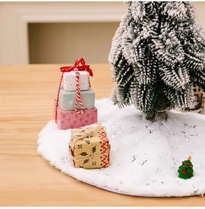 Close-up of white plush Christmas tree skirt with silver star sequins on wood