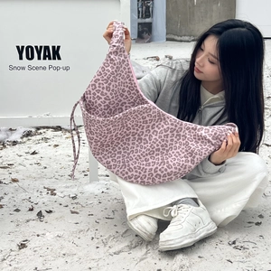 Detail of pink leopard print crescent bag with drawstring texture in snowy outdoor setting