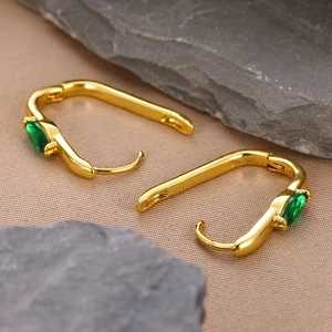 Macro view of 18k gold-plated U-shaped earrings featuring green marquise-cut zircon stones