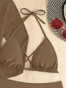 Flat lay of a brown halter bikini with crossover straps and a matching long mesh skirt