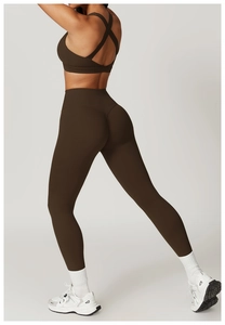 Detail of high waisted yoga pants and cross back sports bra in coffee brown color