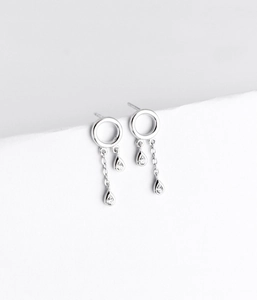 Detail of silver drop tassel earrings with sparkling teardrop-shaped zircon crystals