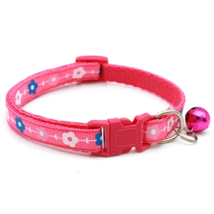 Dettaglio del collare rosa per animali con fiori, fibbia in plastica e campanellino in metallo