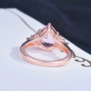 Side view detail of rose gold ring featuring a pear-cut pink stone and micro-pave setting