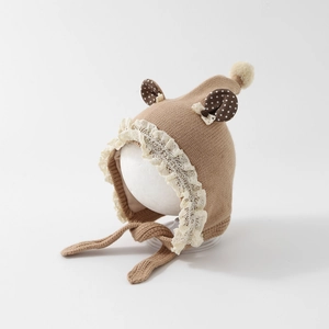 Detail of brown baby knit hat with cream lace trim, ear flaps, and cute animal ear accents