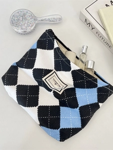 Quilted checkerboard cosmetic bag in black white and blue with zipper closure