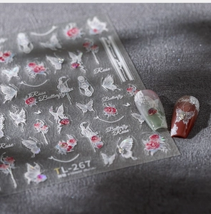 Macro detail of 5D embossed nail stickers featuring rose and butterfly patterns