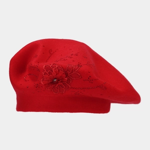 Dettaglio del basco in maglia rossa con fiori 3D e strass rossi scintillanti