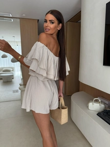 Detail of off-shoulder ruffled beige romper with textured fabric and high waist design