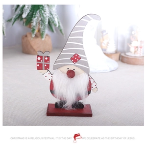 Close-up of wooden Christmas gnome ornament with red hat and soft white faux fur beard