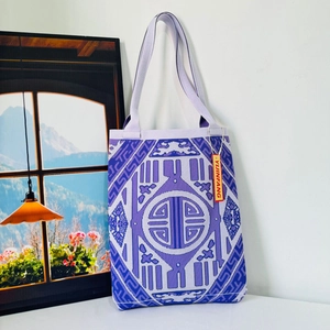 Detailed close-up of purple knit tote bag featuring traditional geometric ethnic patterns