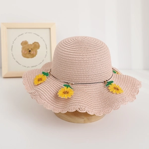 Dettaglio di cappello di paglia estivo con ricamo girasole e bordi a onde