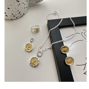 Detail of vintage S925 silver and gold coin jewelry set with embossed portrait design