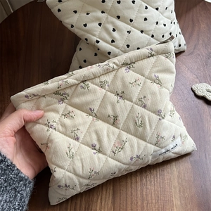 Detailed macro view of quilted corduroy makeup bags with floral and heart patterns