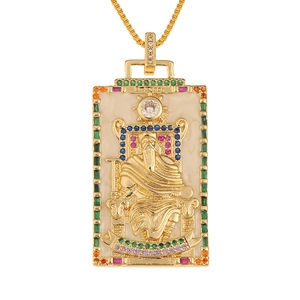 Detail of golden tarot card pendant showing The Emperor relief with colorful crystals