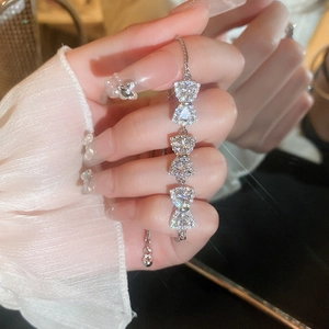 Detail of adjustable silver bow bracelet with sparkling cubic zirconia on female wrist