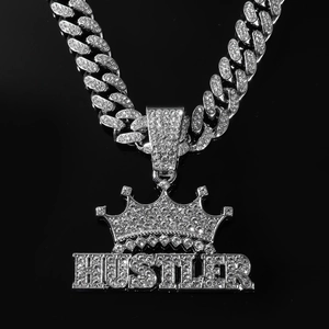 Détail du pendentif HUSTLER argenté avec couronne et strass brillants style hip-hop