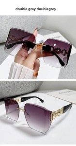 Close-up of double grey gradient lenses and hollow gold metal temples on rimless sunglasses