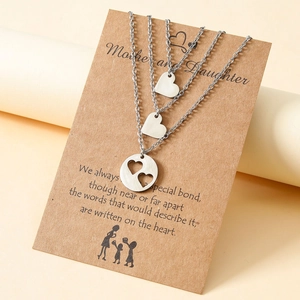 Detail view of three silver heart necklaces with Mother and Daughter poem card