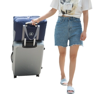 Navy blue foldable travel bag with trolley sleeve on luggage handle for storage