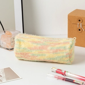 Gros plan d'une trousse en tricot arc-en-ciel avec texture pelucheuse et fermeture éclair