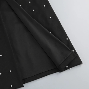 Vue détaillée de perles blanches sur tissu noir pour une robe de soirée de style français