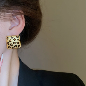 Nahaufnahme von Vintage Gold-Ohrringen mit Leopardenmuster im Retro-Stil an einem Model