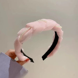 Dettaglio cerchietto in organza rosa plissettata con decorazioni in perle fini