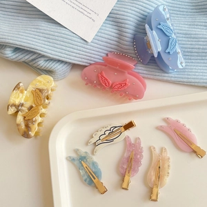 Pastel wing hair clips set with marble texture and rhinestones in a tray