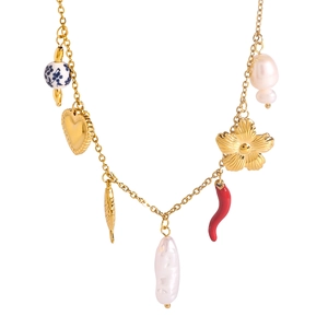 Golden necklace with heart, flower, chili charms and pearls on white background