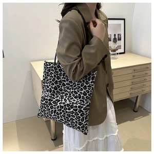 Fashionable leopard print canvas tote bag with black and white pattern shown on shoulder