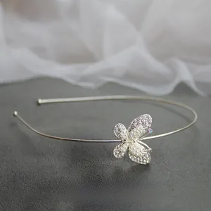 Dettaglio cerchietto argento con farfalla di strass e decorazione centrale di perle