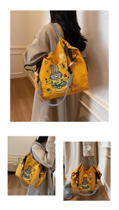 Detail of yellow canvas tote bag featuring cartoon bunny prints and plaid drawstring straps