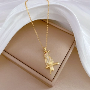 Luxurious gold-plated titanium bird pendant necklace with sparkling crystals on silk fabric
