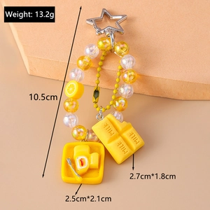 Detail view of yellow beaded keychain with chocolate and fried egg charms and weight specs