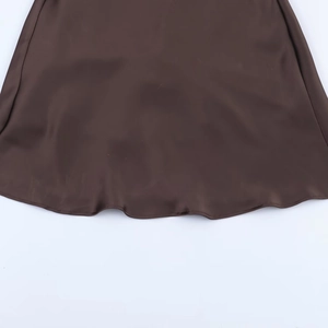 Detail of coffee brown silk satin dress hem showing smooth texture and fine stitching